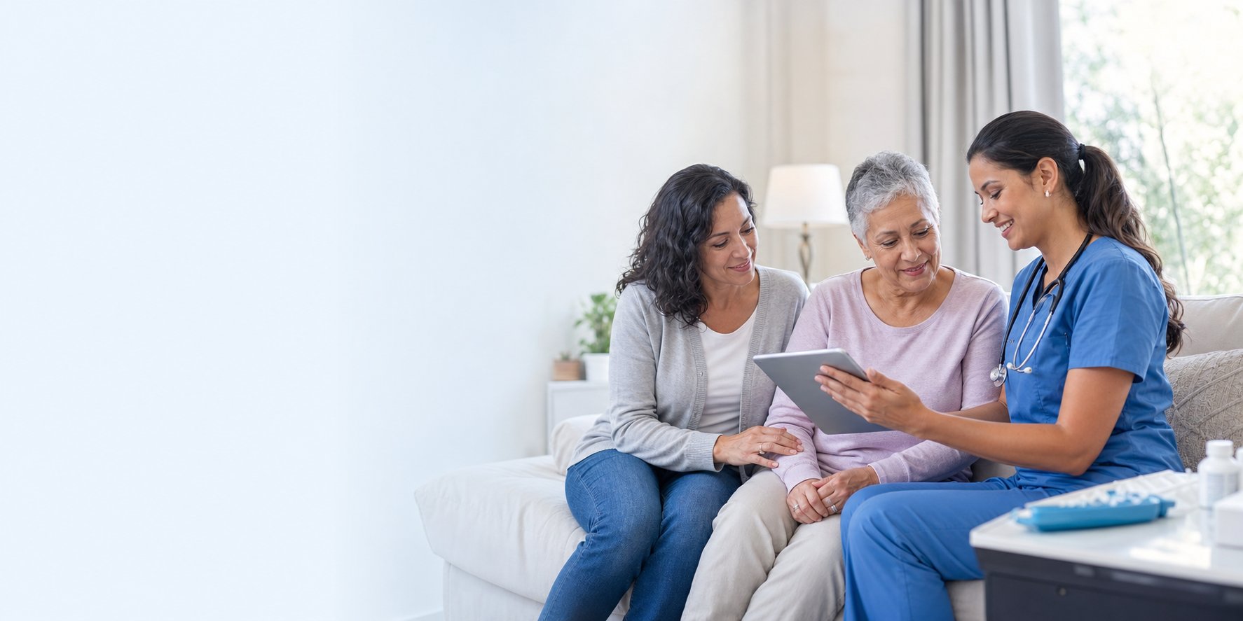 A nurse reviewing care on a tablet with a patient and her family at home